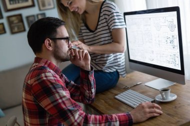 Bilgisayarda çalışan tasarımcıların genç çekici çift