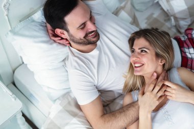 Genç mutlu çift yatak odasında romantik vakit geçiriyor