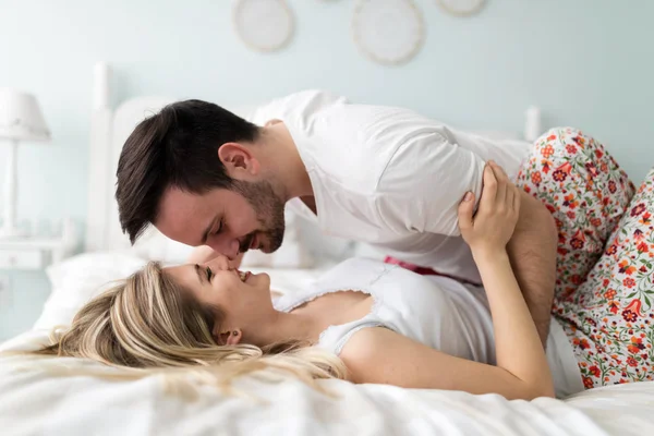 Genç mutlu çift yatak odasında romantik vakit geçiriyor