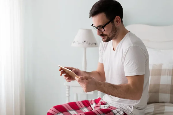 Hombre Joven Guapo Usando Tableta Digital Dormitorio — Foto de Stock