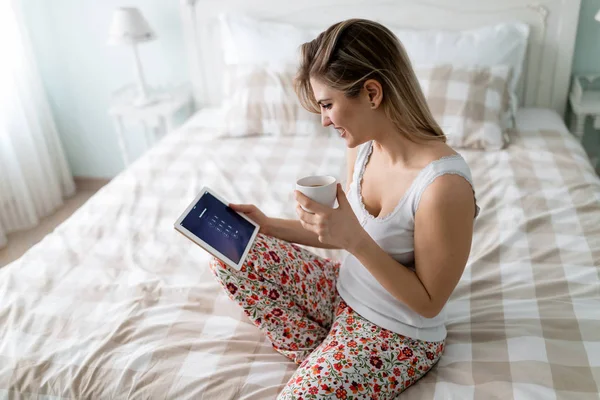Genç Güzel Sarışın Kadın Yatak Odasında Dijital Tablet Kullanma — Stok fotoğraf