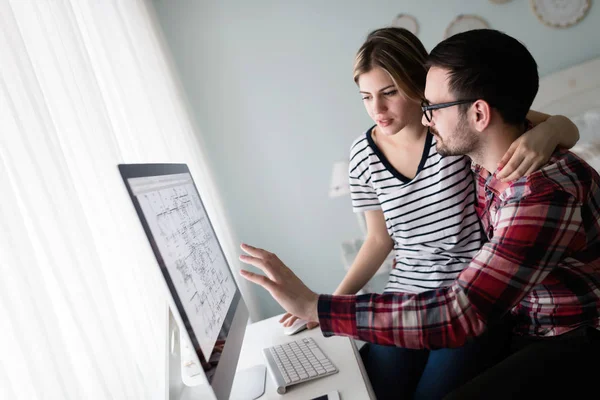 Bilgisayarda çalışan tasarımcıların genç çekici çift