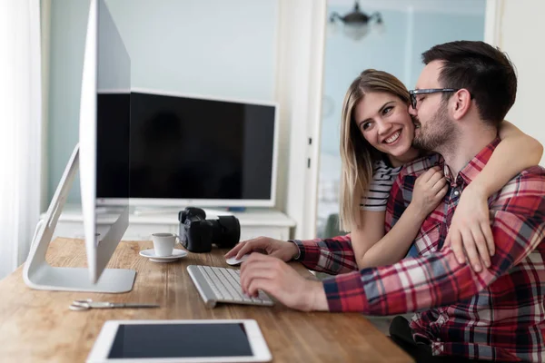Bilgisayarda çalışan tasarımcıların genç çekici çift