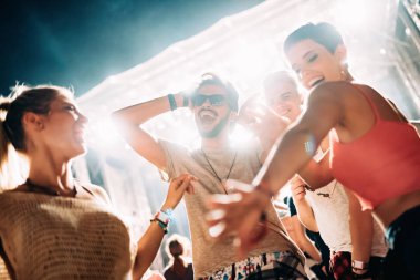 Mutlu genç arkadaşlar müzik festivalinde eğleniyor.