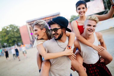 Mutlu genç arkadaşlar müzik festivalinde eğleniyor.