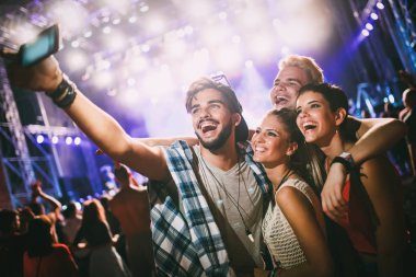 Mutlu genç arkadaşlar müzik festivalinde eğleniyor.