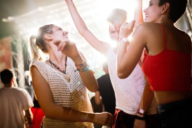 Mutlu genç arkadaşlar müzik festivalinde eğleniyor.