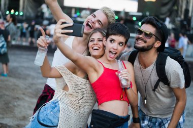 Mutlu genç arkadaşlar müzik festivalinde eğleniyor.