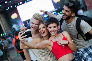 Mutlu genç arkadaşlar müzik festivalinde eğleniyor.