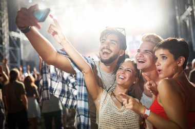 Mutlu genç arkadaşlar müzik festivalinde eğleniyor.