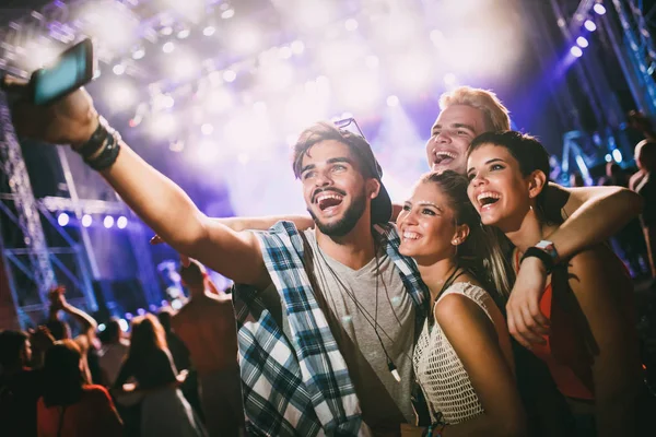 Mutlu genç arkadaşlar müzik festivalinde eğleniyor.