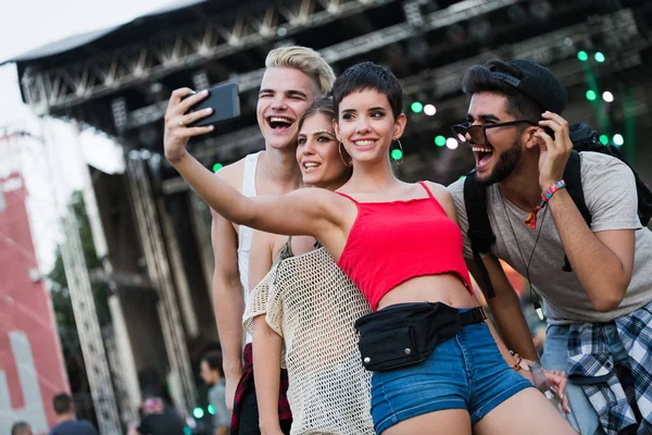 Mutlu genç arkadaşlar müzik festivalinde eğleniyor.