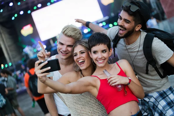 Mutlu genç arkadaşlar müzik festivalinde eğleniyor.