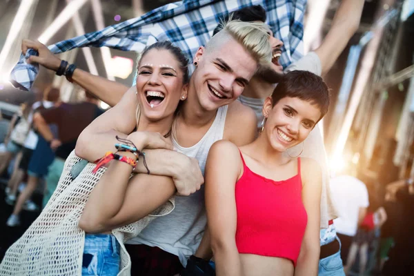 Mutlu genç arkadaşlar müzik festivalinde eğleniyor.
