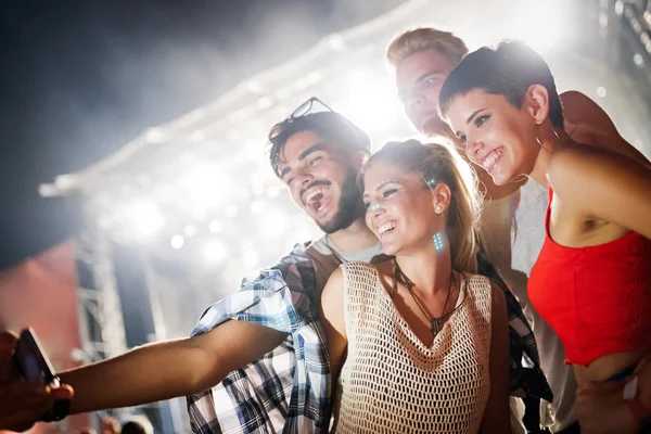 Mutlu genç arkadaşlar müzik festivalinde eğleniyor.