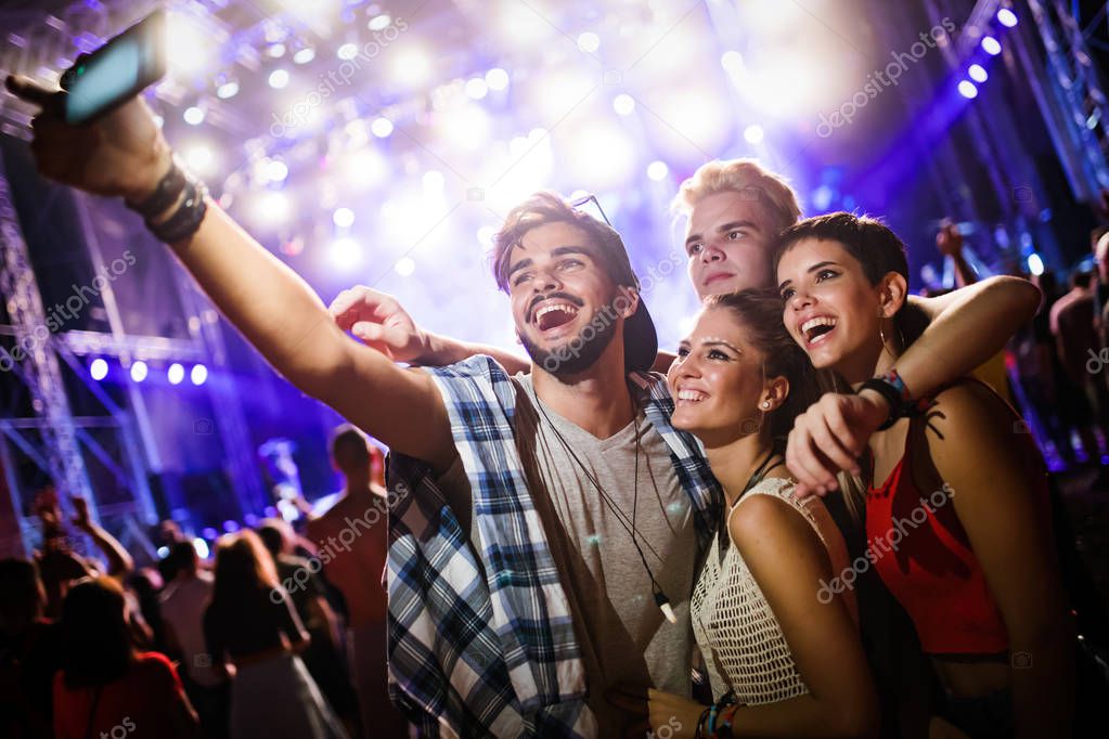 Group of young friends having fun time at music festival