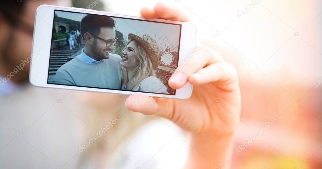 Happy young couple having fun and taking a selfie
