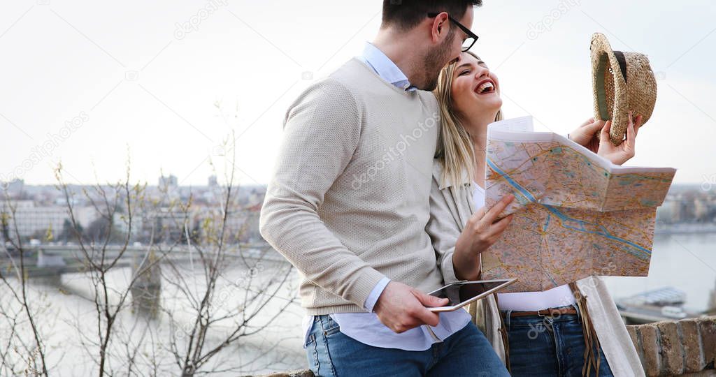 Smiling tourist couple in love traveling with map outdoors