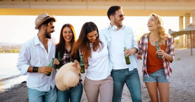 Grup genç neşeli arkadaşıyla yürüyüş ve sahilde bira içmek