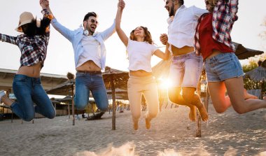 Grup arkadaşları birlikte atlama ve having fun kumsalda