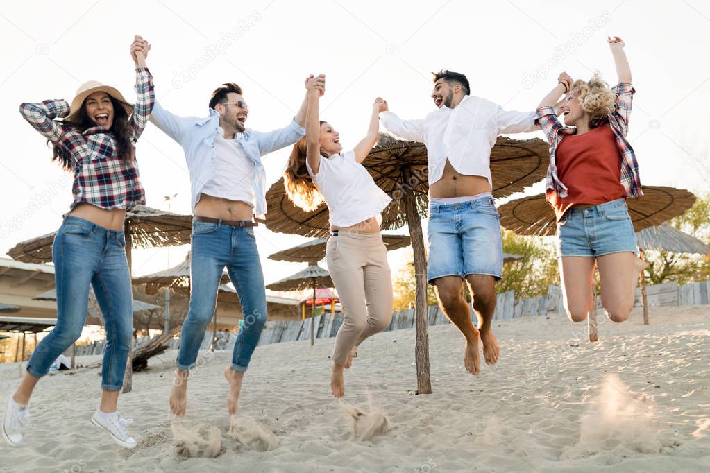 Happy friends partying and having fun on beach at summer