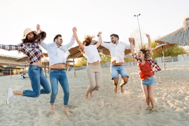 Grup arkadaşları birlikte atlama ve having fun kumsalda
