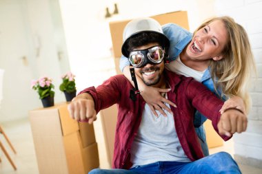 ev, insanlar, hareketli ve gayrimenkul konsept - mutlu çift yeni dairende hareket ederken eğleniyor