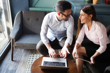 İş arkadaşları laptop bakarken gülüyor