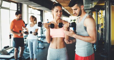 Spor salonunda kişisel eğitmenler ile egzersiz iki çekici kadın