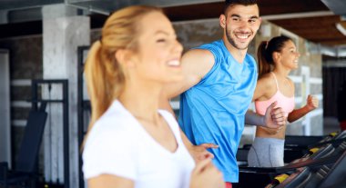 Genç çekici kadın spor salonunda ağırlık kaybı için kardiyo egzersizi yapıyor