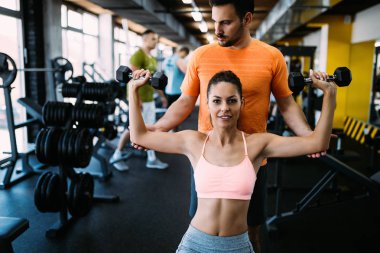 Spor salonunda özel antrenör öğrenciye talimat veriyor.