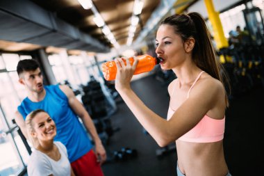 spor salonunda egzersiz sırasında genç kadın içme suyu