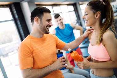 Genç ve güzel bir kadın spor salonunda antrenörle egzersiz yapıyor.