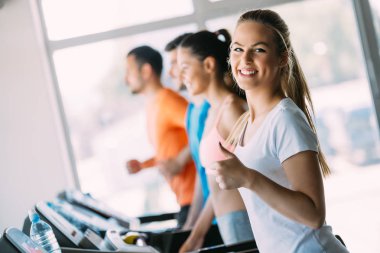 Bir koşu bandı spor salonunda egzersiz ve gülümseyen güzel kız