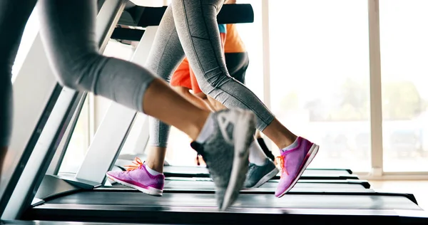 Group of friends exercising on treadmill machine in gym