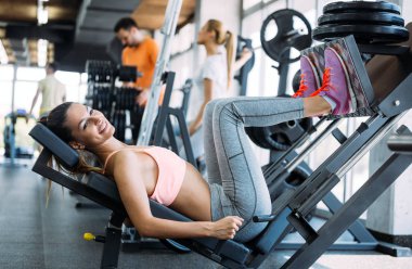 Genç güzel kadının bacakları içinde jimnastik salonu için egzersizler yapması