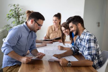 İş ortaklarının toplantıda belge ve fikirleri tartıştığı resim
