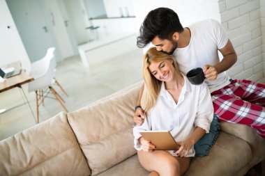 Mutlu çift evde tablet üzerinde sörf aşık