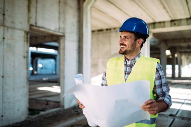 Mühendis bir mavi parmak tutan bir şantiyeye çalışıyor
