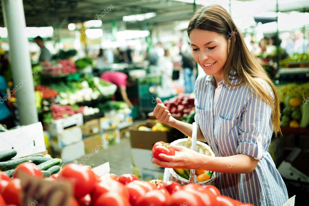 Picture of beautiful woman at marketplace buying vegetables