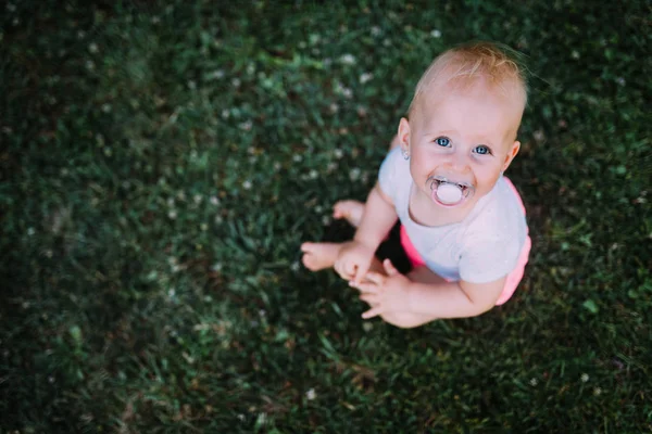 Portret piękne dziecko siedzi na trawniku — Zdjęcie stockowe