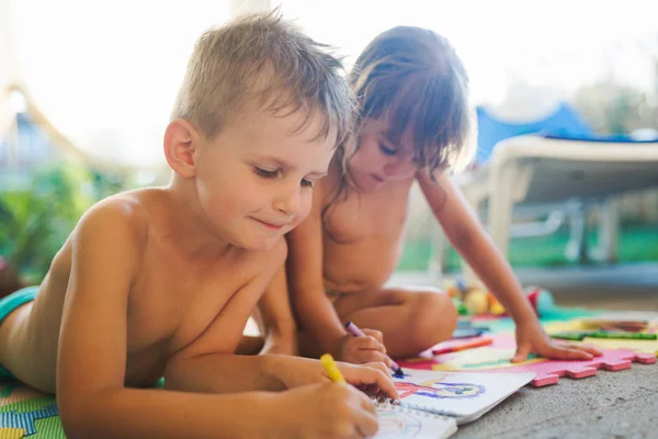 Kleine Jungen und Mädchen zeichnen mit Buntstiften — Stockfoto