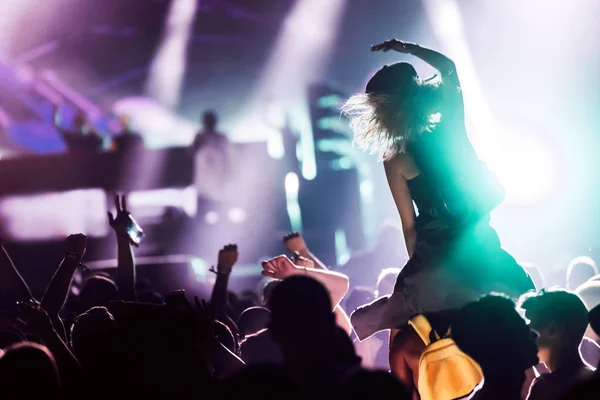 Cheering crowd with hands in air enjoying at music festival