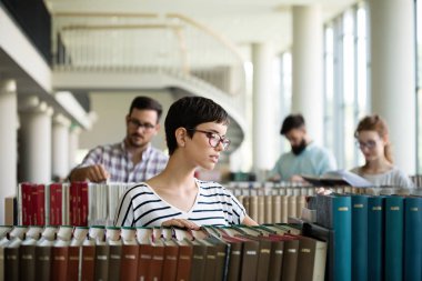 Bir kitap alarak Kütüphanesi'nde mutlu kadın