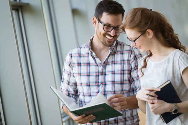 Glückliches Schülerpaar Der Schulbücherei Diskutiert Über Buch — Stockfoto