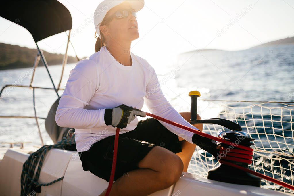 Attractive strong sport woman sailing with her boat