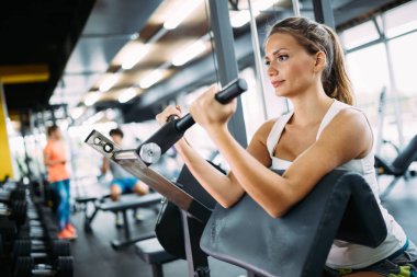 Genç güzel kadın için spor salonunda pazı egzersizleri yapıyor
