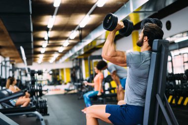 Spor salonunda egzersiz yapan genç yakışıklı güçlü erkek