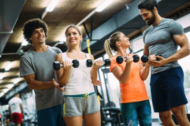 Genç güzel kadın spor salonunda kişisel eğitmenler ile yapıyor