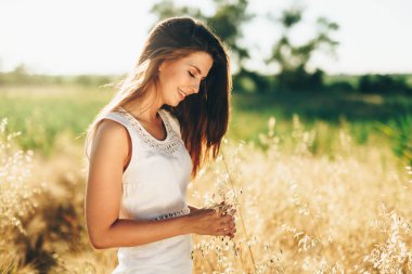 Genç, güzel, mutlu bir kadın doğada vakit geçiriyor.